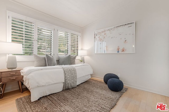 bedroom with vaulted ceiling and wood-type flooring