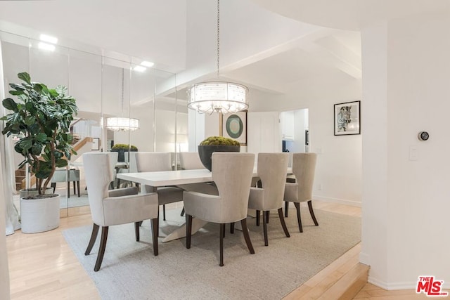 dining area featuring light wood-type flooring and a notable chandelier