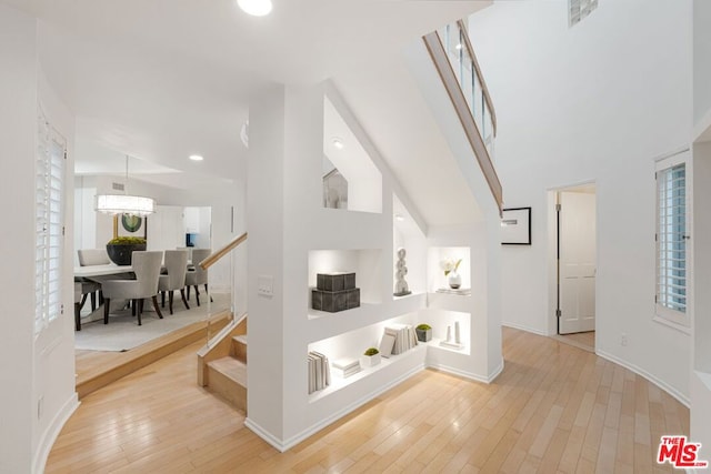 interior space with a towering ceiling and light wood-type flooring