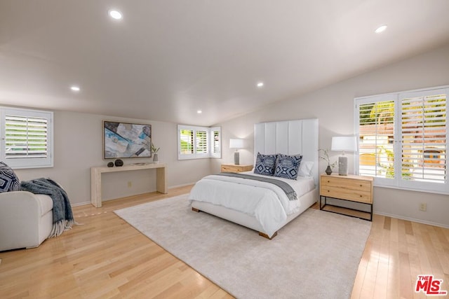 bedroom featuring lofted ceiling and light wood-type flooring