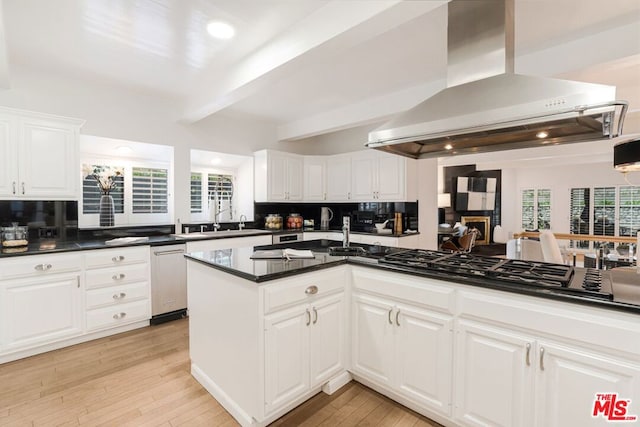 kitchen featuring island exhaust hood, stainless steel appliances, beam ceiling, white cabinets, and sink