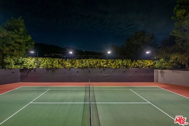 view of tennis court with basketball hoop