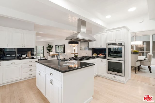 kitchen featuring island range hood and white cabinets