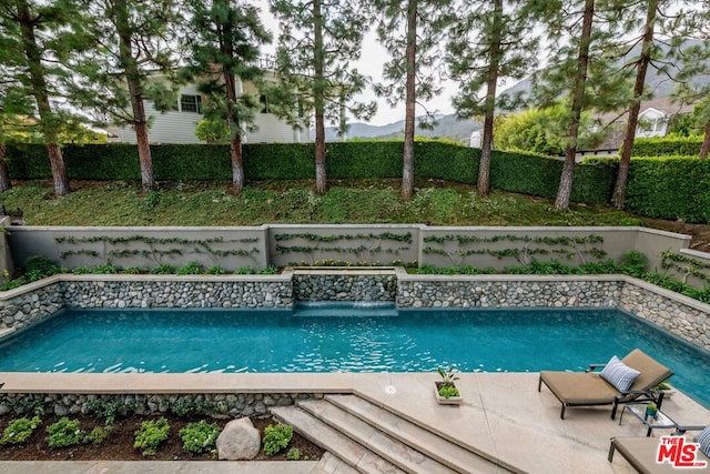 view of pool with pool water feature and a mountain view