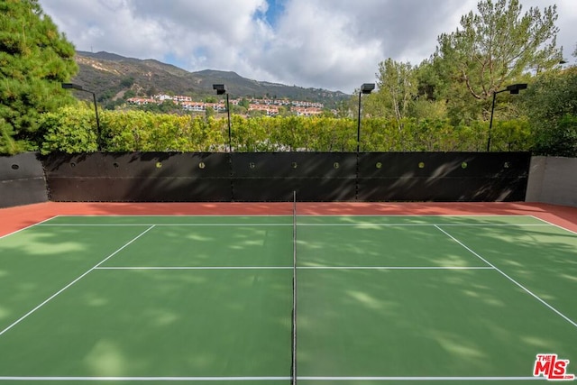 view of tennis court featuring a mountain view and basketball hoop