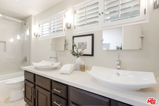 full bathroom with toilet, tiled shower / bath, and vanity