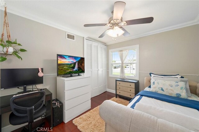 bedroom with dark hardwood / wood-style flooring, a closet, ceiling fan, and crown molding