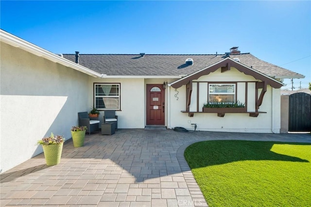 doorway to property with a patio area and a yard