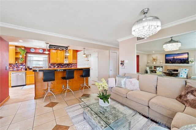 tiled living room with crown molding and a chandelier