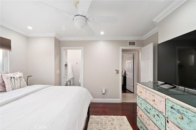 bedroom featuring ceiling fan, dark hardwood / wood-style flooring, and crown molding