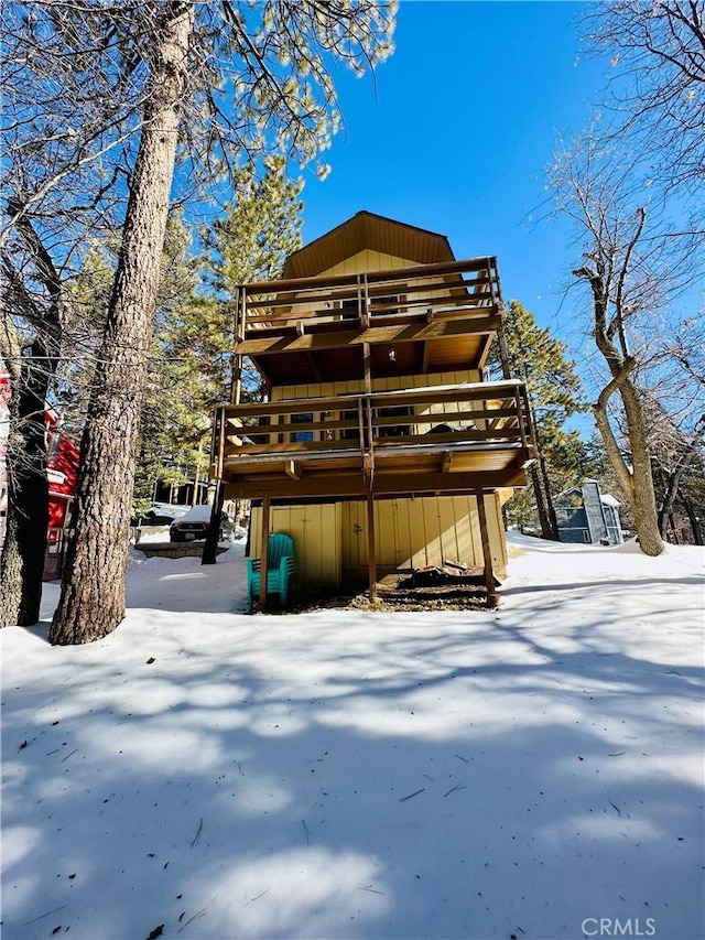 snow covered house featuring a deck