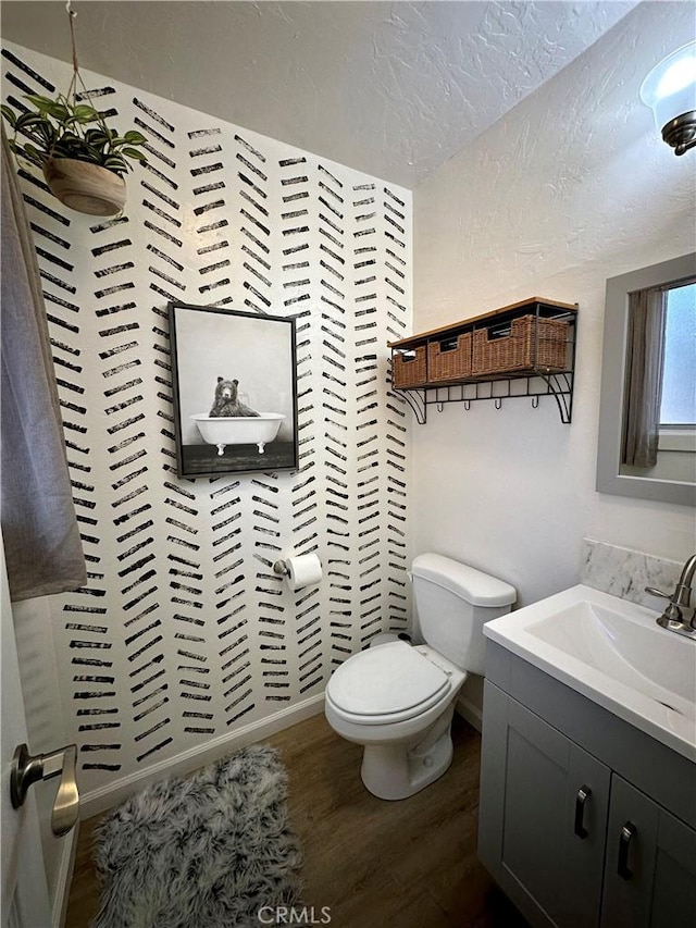 bathroom featuring hardwood / wood-style floors, vanity, toilet, and a textured ceiling