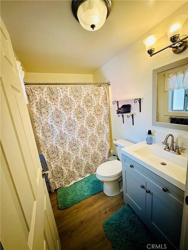 full bathroom featuring vanity, toilet, and wood finished floors