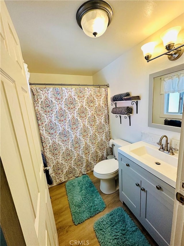 bathroom with hardwood / wood-style floors, vanity, and toilet