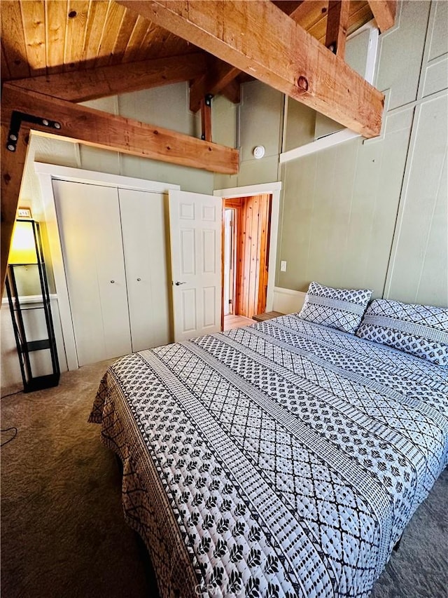 bedroom featuring vaulted ceiling with beams, a closet, carpet flooring, and wood ceiling