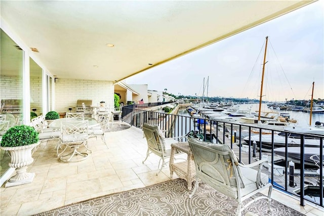 balcony with area for grilling and a water view