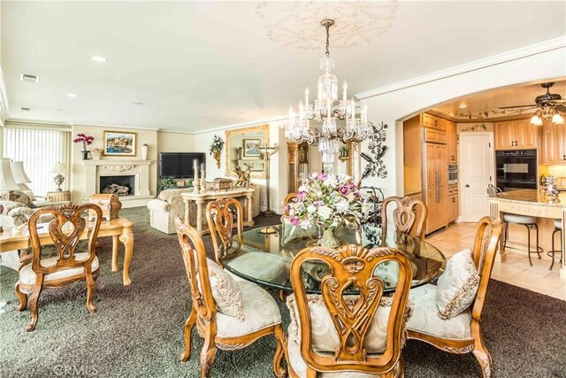 dining room featuring crown molding, light tile patterned flooring, and ceiling fan with notable chandelier