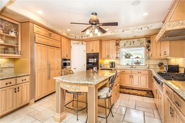 kitchen featuring a kitchen bar, paneled refrigerator, premium range hood, a center island, and stainless steel gas stovetop