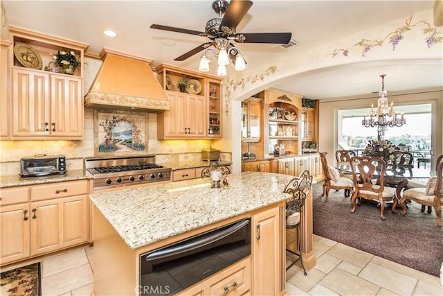 kitchen with light stone countertops, light brown cabinets, pendant lighting, a kitchen island, and custom exhaust hood