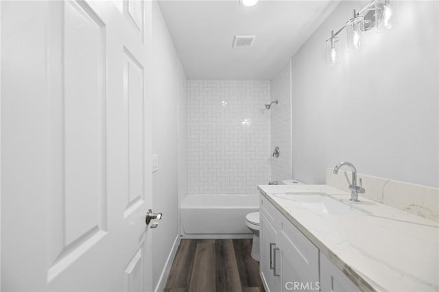 full bathroom featuring vanity, toilet, wood-type flooring, and tiled shower / bath combo