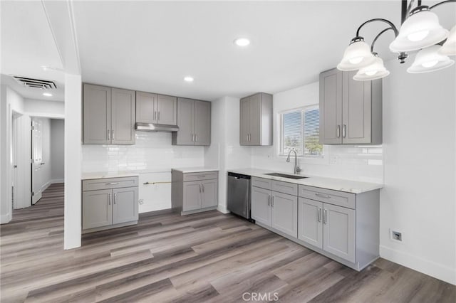 kitchen featuring sink, stainless steel dishwasher, dark hardwood / wood-style floors, gray cabinets, and decorative light fixtures