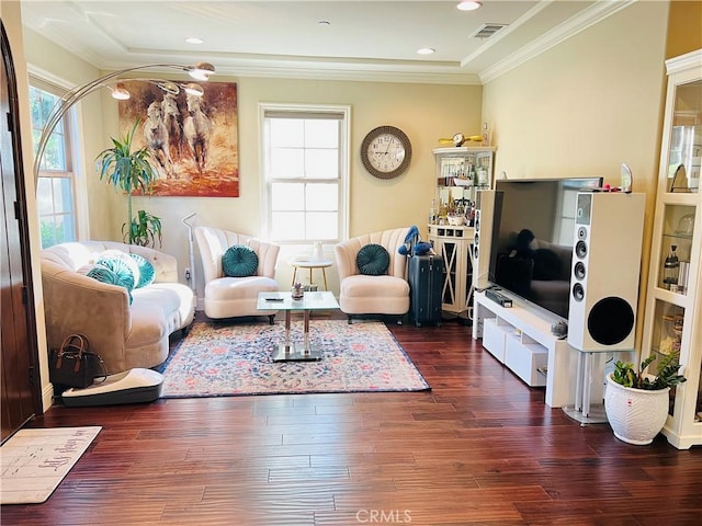 living room featuring dark hardwood / wood-style flooring, a wealth of natural light, and ornamental molding