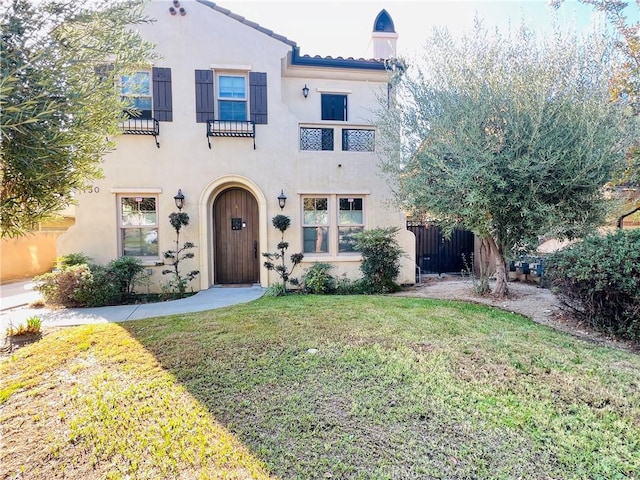 mediterranean / spanish-style home with a front yard