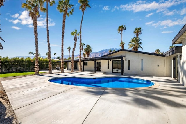 view of swimming pool with a patio area and a mountain view