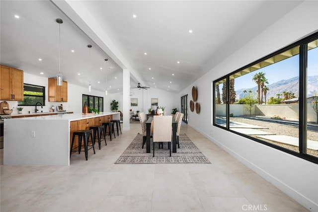 dining room featuring a mountain view, sink, ceiling fan, and vaulted ceiling