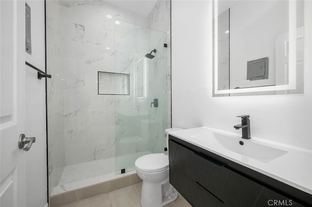 bathroom featuring toilet, a tile shower, and vanity