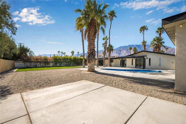 exterior space with a fenced in pool, a patio, fence, and a mountain view