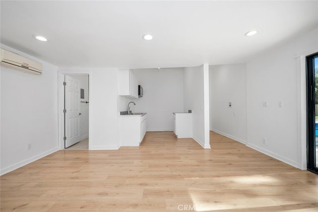 interior space featuring a wall unit AC, light wood-type flooring, and sink