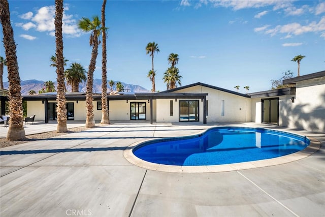 view of swimming pool featuring a mountain view and a patio area