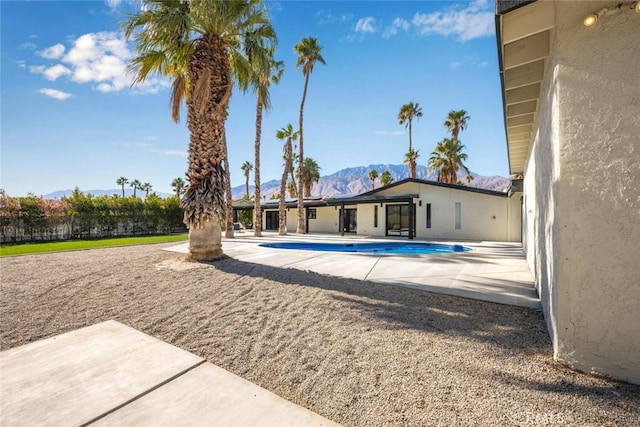 view of swimming pool with a patio area and a mountain view