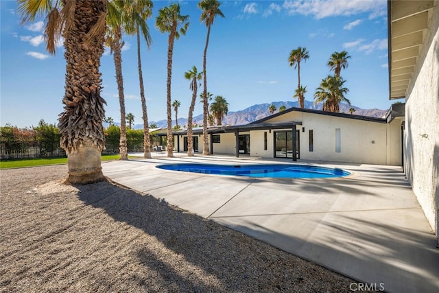 view of swimming pool featuring a patio area and a mountain view