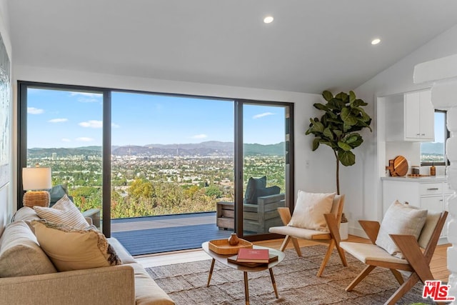 interior space featuring plenty of natural light, a mountain view, lofted ceiling, and light hardwood / wood-style flooring