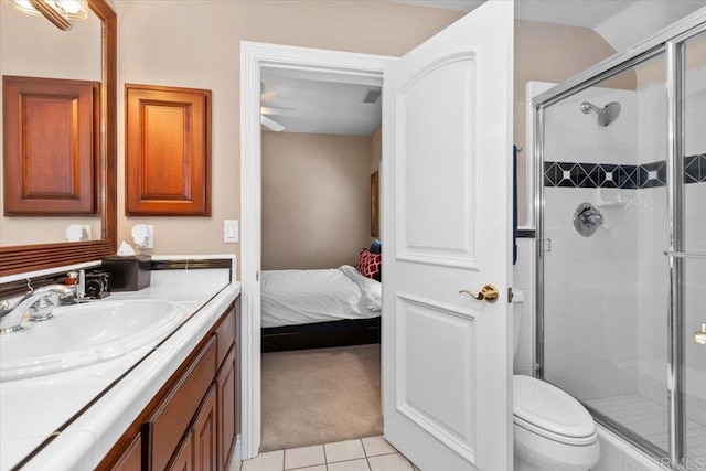 bathroom featuring tile patterned flooring, vanity, toilet, and a shower with shower door