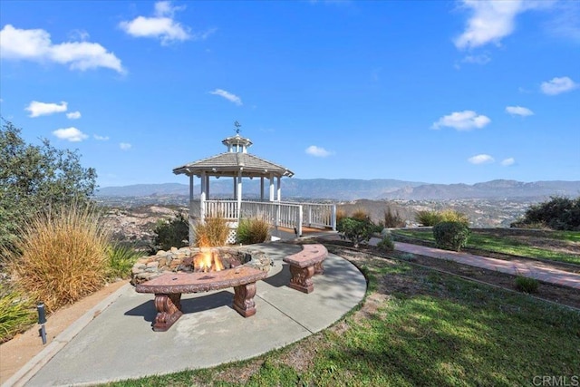 view of patio featuring a gazebo, a mountain view, and a fire pit