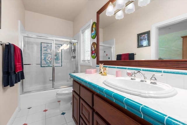 full bathroom featuring tile patterned floors, vanity, enclosed tub / shower combo, and toilet