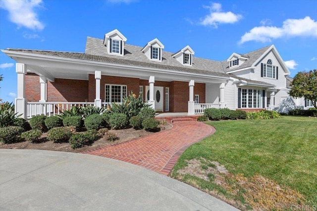 cape cod home featuring a porch and a front lawn