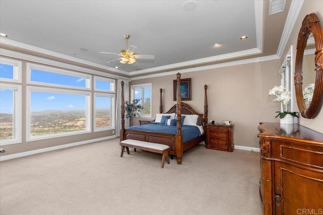 carpeted bedroom featuring ceiling fan, a raised ceiling, and crown molding