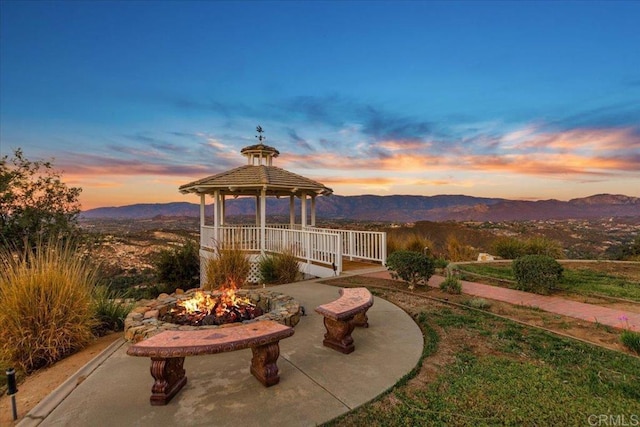 patio terrace at dusk with a gazebo and a mountain view