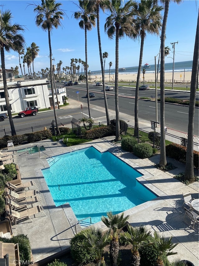 view of swimming pool with a water view and a patio