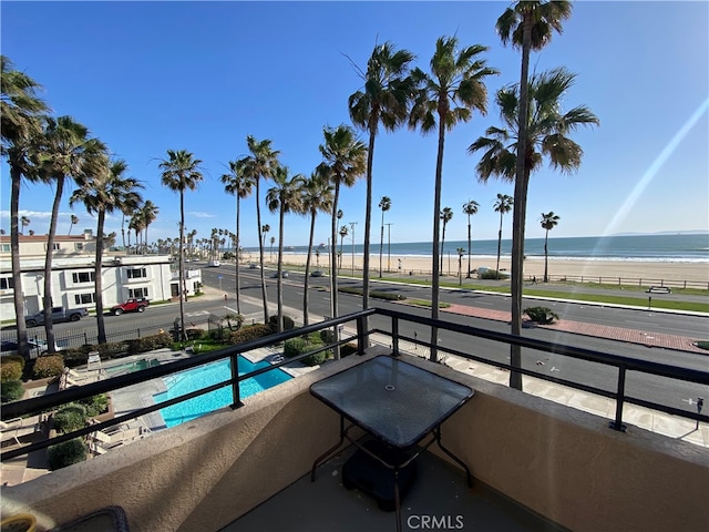 view of swimming pool with a water view and a beach view