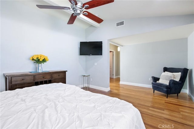 bedroom with baseboards, visible vents, ceiling fan, wood finished floors, and vaulted ceiling