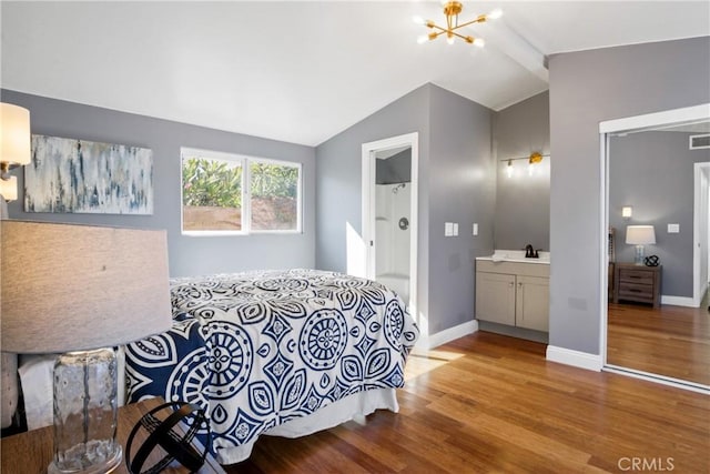 bedroom featuring a chandelier, visible vents, baseboards, vaulted ceiling, and light wood-style floors