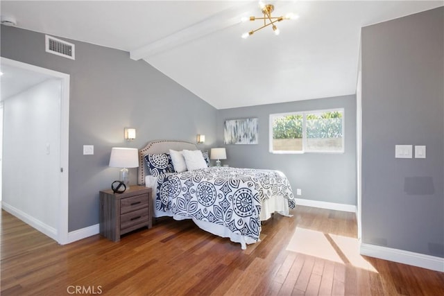 bedroom featuring vaulted ceiling with beams, visible vents, baseboards, and wood finished floors