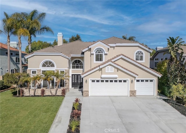 view of property with a garage and a front lawn