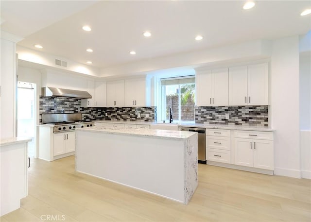 kitchen with a kitchen island, white cabinetry, and appliances with stainless steel finishes