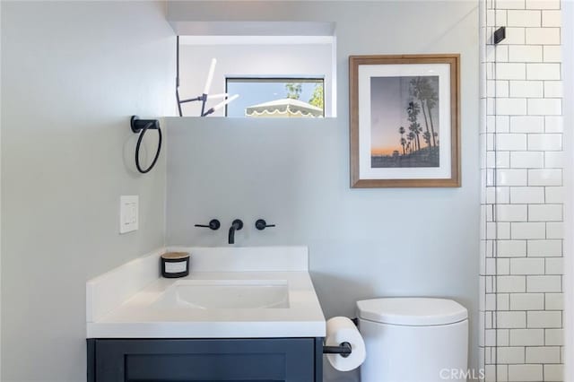 bathroom featuring vanity, toilet, and walk in shower